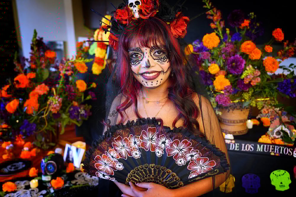 Student dressed in costume with Halloween decor behind her.