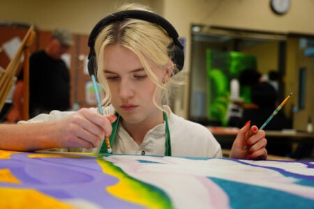 Female painter with headphones on.