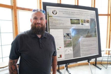 Ag student standing in front of his project.