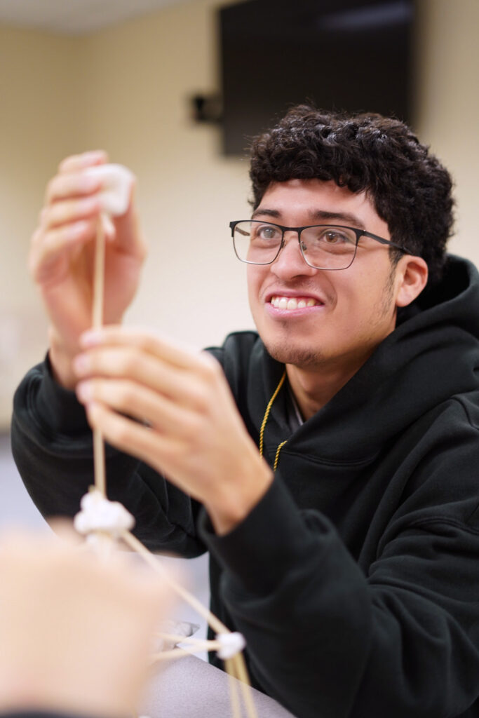 Male student working with toothpicks and marshmallows