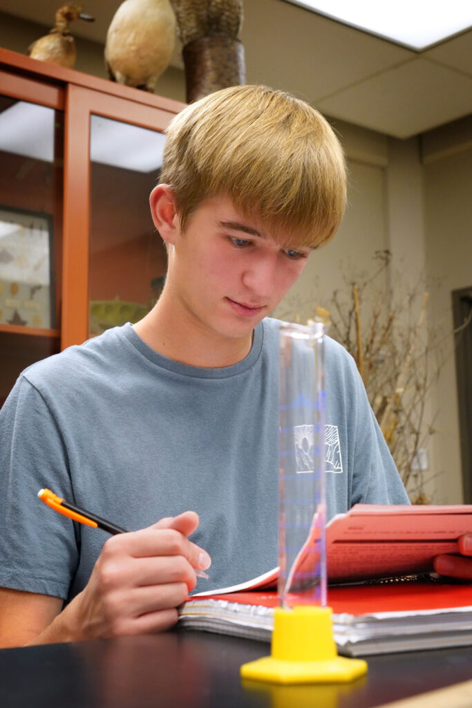 Blonde male student studying in science class
