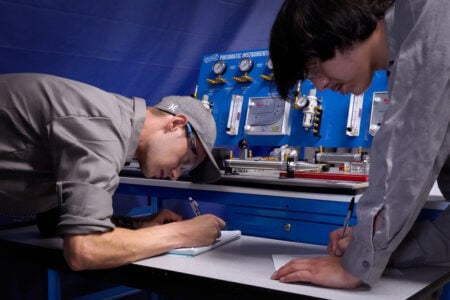 Two male students working on an energy systems lab.