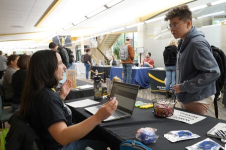 Staff assist students at an information table during a Walla Walla Community College campus event.