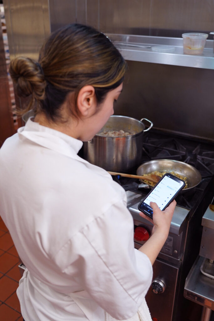 Culinary student holding phone using the Meez App