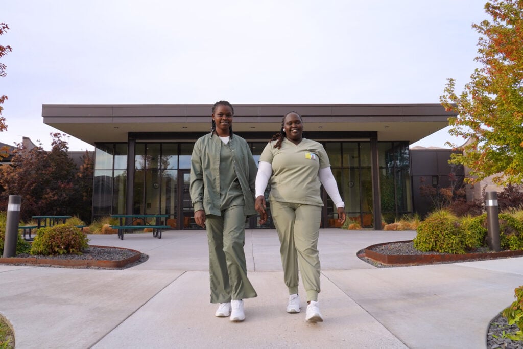 nursing students walking in pathway, building behid