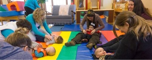 parents interacting with babies on floor