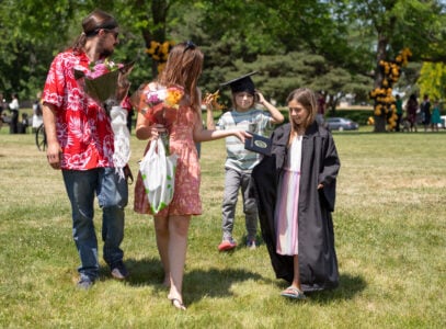 parent passing diploma to kid