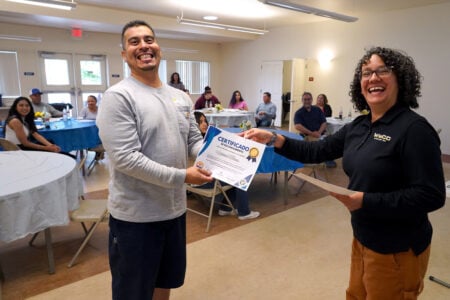 A student receives a certificate of recognition from a Walla Walla Community College staff member during a campus event