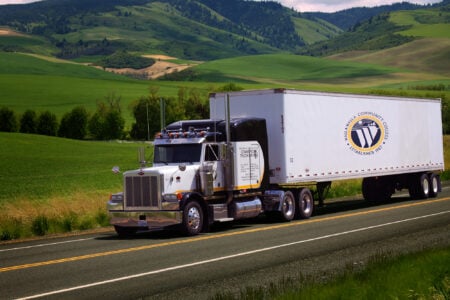 A Walla Walla Community College commercial truck driving semi travels along a rural highway.