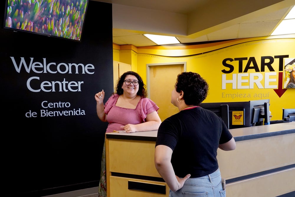 Student being welcomed at the front desk