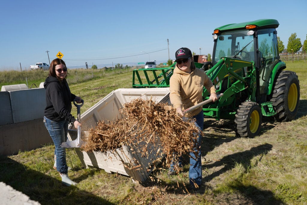 two girls spreading shredded compost